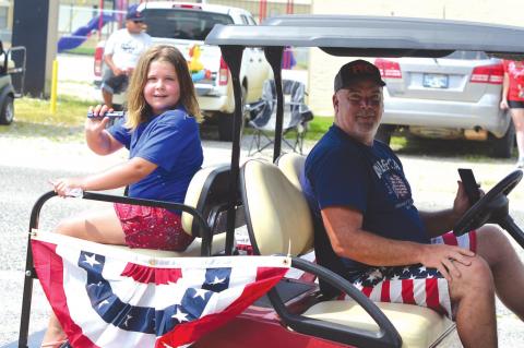 Kami and William showing off their neighbor Harold Akins golf cart.