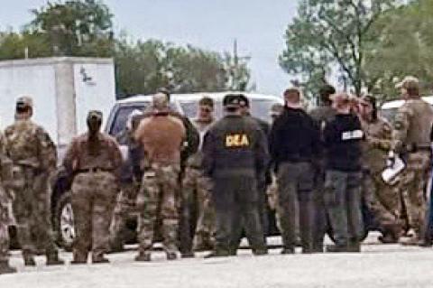 Law enforcement agents gather before raid.