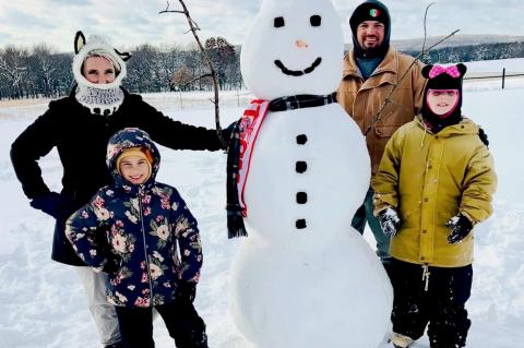 The Escarcega family enjoyed the snow. Pictured are Robin and Alex and their twins Evie and Rozzlyn with their stylish snowman.
